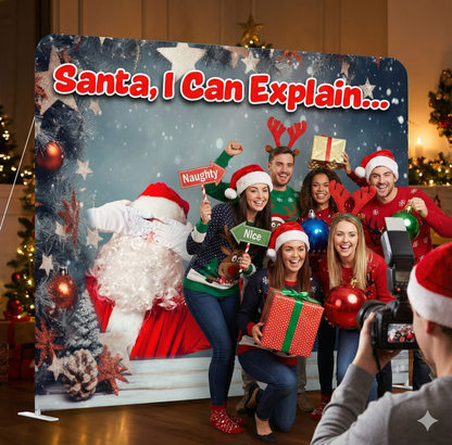 Group of people posing in front of a Christmas-themed backdrop with text 'Santa, I Can Explain'.